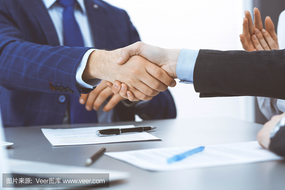 商人們握手,完成一份文件簽名。會議、合同及律師咨詢理念